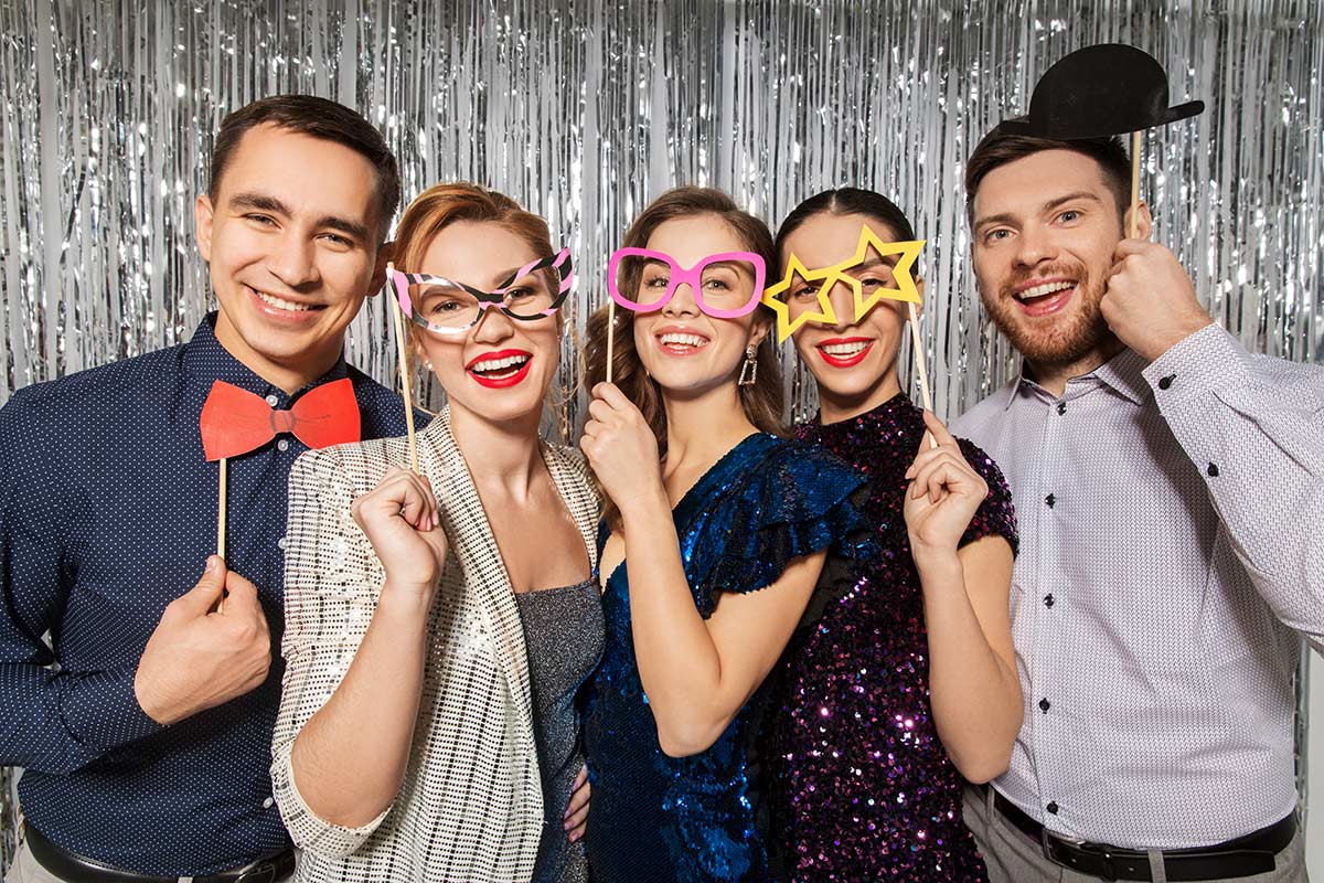Baby shower photo booth ideas with friends posing with photo booth props on sticks